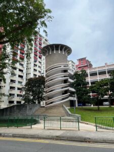 Interesting spiral staircase built to look like the tower of a castle, leading up a humble public car park