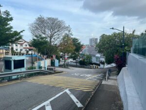 Steep slope with narrow path obstructed by metal barriers