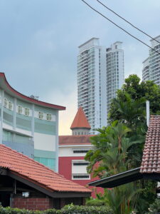Catholic High's Indoor Sports Hall and "castle turret" seen from Jalan Insaf, with Natura Loft HDB development in the background.